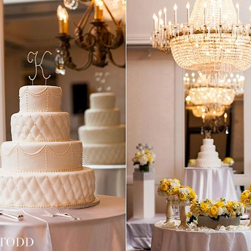 The image shows a tiered wedding cake with a 'K' topper, alongside floral decorations and chandeliers in an elegant setting.