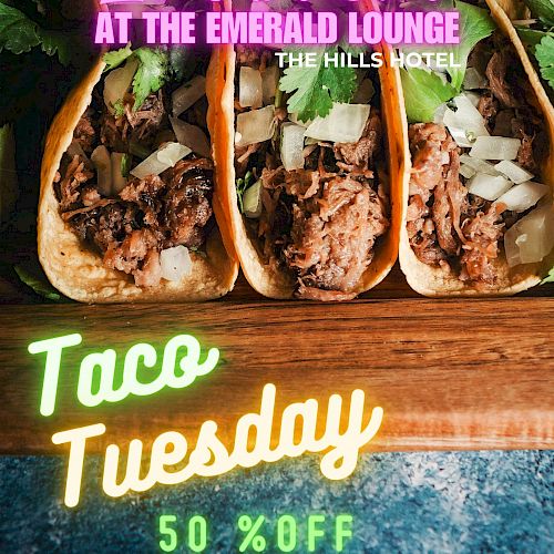 A promotional image for Taco Tuesday at the Emerald Lounge, offering 50% off. The image shows tacos with the text 